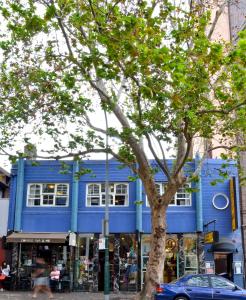 a blue building with a tree in front of it at PodBed Sydney in Sydney