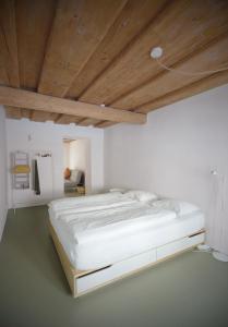 a bed in a room with a wooden ceiling at HERZIGE WOHNUNG IN ALTEM GEMÄUER in Linz