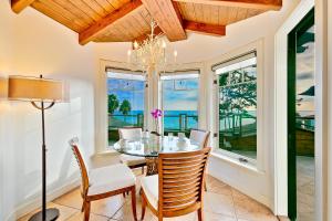 a dining room with a table and chairs and windows at Cliff Dr View in Laguna Beach