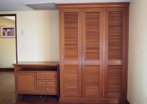 a wooden closet with a dresser and a mirror at Spacious room 55 sq.m. Central BKK close to Nana BTS in Bangkok
