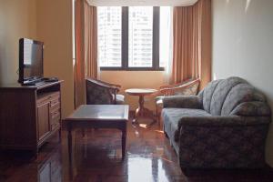 a living room with a couch and a tv at Spacious room 55 sq.m. Central BKK close to Nana BTS in Bangkok
