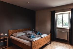 ein Schlafzimmer mit einem Bett mit blauen Kissen und einem Fenster in der Unterkunft Hotel Cornelyshaff in Heinerscheid