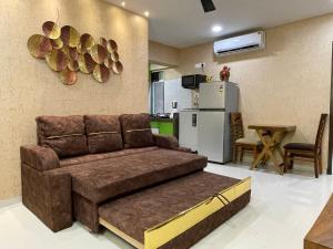 a living room with a couch and a kitchen at OSI Apartments Bandra West in Mumbai