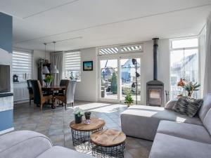 a living room with a couch and a fireplace at Detached vacation home in Friesland with waterfront views in Grou