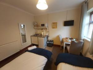 een kamer met 2 bedden, een tafel en een bureau bij Sergeants Accommodation in Nelson