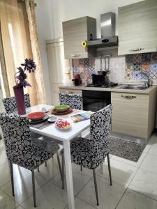 Il comprend une cuisine avec une table et des chaises blanches. dans l'établissement Casa vacanza Francesca, à Leonforte