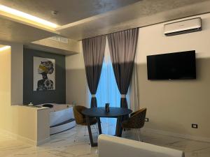 a living room with a table and a tv and a tub at Club Hotel Kennedy in Roccella Ionica