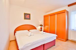 a bedroom with a bed with a wooden headboard at Hotel Barborka in Přední Výtoň