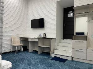 a room with a desk and a tv on a wall at Lola Kokand Hotel in Kokand