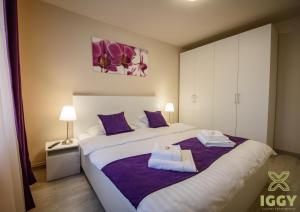 1 dormitorio con 1 cama grande y toallas. en Iggy Luxury Apartment en Hunedoara