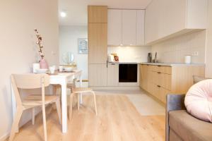 cocina y sala de estar con mesa blanca y sillas en Hygge Malta - NOWY apartament, en Poznan