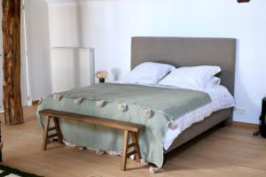 1 dormitorio con 1 cama grande y suelo de madera en La ferme de Basseilles, en Mozet 