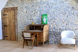 Mozet 的住宿－La ferme de Basseilles，一张桌子和两把椅子,旁边是石墙