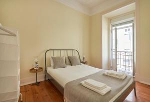 una camera da letto con un letto e due asciugamani di Renovated Spacious Baixa Apartment, By TimeCooler a Lisbona