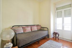 una camera con un letto con una finestra e una lampada di Renovated Spacious Baixa Apartment, By TimeCooler a Lisbona