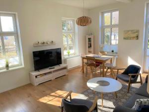 a living room with a television and a table and chairs at Wohnung Luv - Alte Schule in Glowe