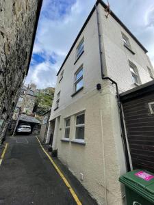 a white building with windows on a street at Flat 2, Ty Newydd in Barmouth