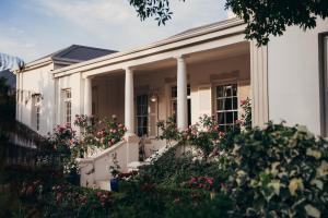 a white house with flowers in front of it at Les Chambres Guest House in Franschhoek