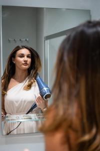 kobieta susząca włosy przed lustrem w obiekcie Alpha Studios (Adults Only) w mieście Naksos