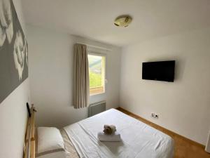 a bedroom with a bed and a flat screen tv at 3 pièces la Foux d Allos vue montagne et station in La Foux