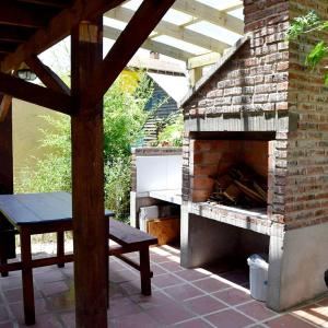 um pátio com uma lareira de tijolos e uma mesa e banco em Cabaña Picaflores em Barra de Valizas