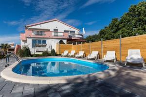 Galovac的住宿－Holiday Home Maroko, with private pool，一个带椅子的游泳池以及一座房子