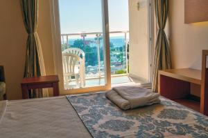 1 dormitorio con 1 cama y ventana grande en Blue Fish Hotel, en Konaklı