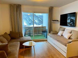 a living room with a couch and a large window at 3 pièces la Foux d Allos vue montagne et station in La Foux