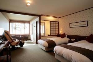 A bed or beds in a room at Shikotsuko Onsen Lake Side Villa SUIMEIKAKU-Adult Only