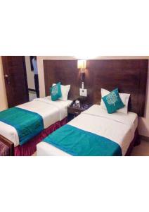 two beds in a hotel room with green pillows at Shining star in Bodh Gaya