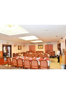 a conference room with tables and chairs and a person in the background at Shining star in Bodh Gaya