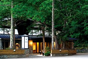 Shikotsuko Onsen Lake Side Villa SUIMEIKAKU-Adult Only في تشيتوسي: مبنى امامه اشجار