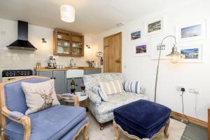 a living room with a couch and a chair at Bijou Coastal Apartment in Polperro with Onsite Parking in Polperro