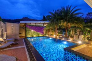 basen w nocy z palmami i światłami w obiekcie 3 Bedroom Platinum Pool Villa Smooth as Silk w mieście Ban Khlong Haeng
