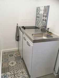 a small kitchen with a sink and a tile floor at Angers, La Belle De Maine in Angers