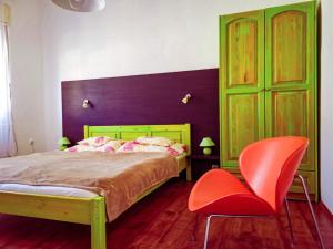 um quarto com uma cama e uma cadeira vermelha em Apartment for 5 ppl at Lake Balaton em Balatonfenyves