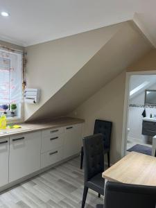 a kitchen with white cabinets and a table and chairs at Zentral gelegenes Apartment in Mönchengladbach mit W-Lan MG08 in Mönchengladbach +5 photos