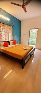 a large bed in a room with a ceiling fan at Royal Black Pepper Cottage in Yercaud