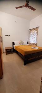 a bedroom with a bed and a ceiling fan at Royal Black Pepper Cottage in Yercaud