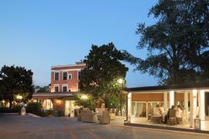 a group of people sitting in chairs outside of a building at Montespina Park Hotel in Naples