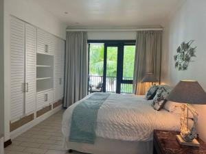 1 dormitorio con 1 cama grande y balcón en Waterfront Maison by Simply-Seychelles en Eden Island