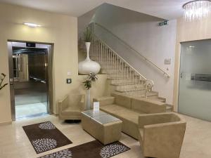 a lobby with a staircase and a couch and a table at Hotel Michael in Gerasdorf bei Wien