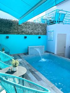 a swimming pool with a fountain in a building at Sunday Downtown @ Rincon in Rincon