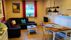 a living room with a couch and a table at Ferienhaus Kleiner Waldstein in Weißdorf