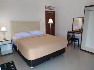 a bedroom with a bed and a table and a mirror at House of Soulmate in Demangan