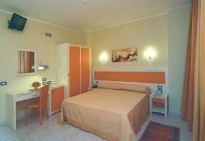 una camera d'albergo con letto, scrivania di Hotel Cristal Eboli a Eboli