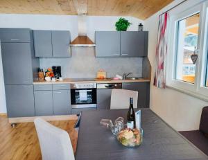 a kitchen with a table with a bottle of wine at Haus Blickfang in Neustift im Stubaital