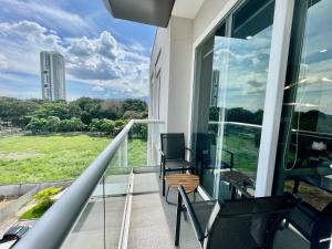 einen Balkon mit Stühlen und Blick auf ein Gebäude in der Unterkunft Amplio condominio ejecutivo con hermosa vista in San Pedro Sula