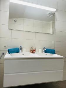 La salle de bains est pourvue d'un lavabo blanc et d'un miroir. dans l'établissement Haus Blickfang, à Neustift im Stubaital