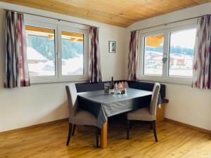 a dining room with a table and chairs and windows at Haus Blickfang in Neustift im Stubaital